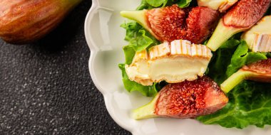 Salata inciri, yumuşak peynir, yeşil yaprak marul lezzetli aperatif lezzetli lezzetli gurme yemek arkaplan masa üzerinde rustik gıda üst görünüm fotokopi alanı keto ve paleo diyet vejetaryen gıda