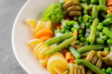 Trottole makarna sebzeler yeşil bezelye, yeşil fasulye, kohlrabi lahanası, brokoli ikinci yemek lezzetli çerez taze lezzetli gurme yemek arka planı masa kırsal gıda üst görünüm boşluk