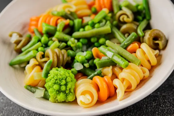 Trottole makarna sebzeler yeşil bezelye, yeşil fasulye, kohlrabi lahanası, brokoli ikinci yemek lezzetli çerez taze lezzetli gurme yemek arka planı masa kırsal gıda üst görünüm boşluk