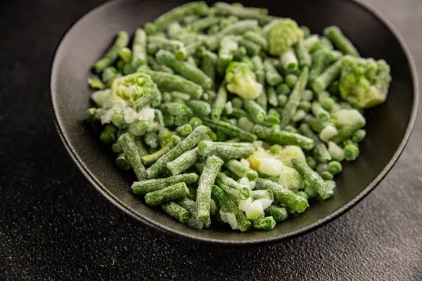 Donmuş yeşil sebzeler bezelye, brokoli, çalı fasulyesi, kohlrabi lahanası lezzetli çerez masadaki lezzetli gurme yemek arka planı rustik yemekler fotokopi alanı keto ve paleo diyeti vejetaryen ve vejetaryen yemekleri.