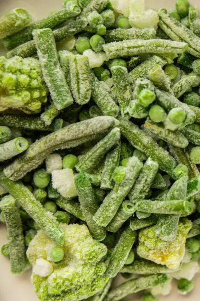 Donmuş yeşil sebzeler bezelye, brokoli, çalı fasulyesi, kohlrabi lahanası lezzetli çerez masadaki lezzetli gurme yemek arka planı rustik yemekler fotokopi alanı keto ve paleo diyeti vejetaryen ve vejetaryen yemekleri.