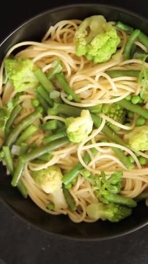 Spagetti sebzesi, bezelye, brokoli, çalı fasulyesi, kohlrabi vejetaryen makarna lezzetli makarna masanın üzerinde taze lezzetli gurme yemek.