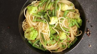 Spagetti sebzesi, bezelye, brokoli, çalı fasulyesi, kohlrabi vejetaryen makarna lezzetli makarna masanın üzerinde taze lezzetli gurme yemek.