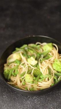 Spagetti sebzesi, bezelye, brokoli, çalı fasulyesi, kohlrabi vejetaryen makarna lezzetli makarna masanın üzerinde taze lezzetli gurme yemek.