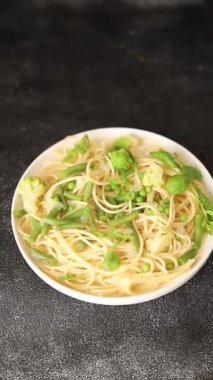 Spagetti sebzesi, bezelye, brokoli, çalı fasulyesi, kohlrabi vejetaryen makarna lezzetli makarna masanın üzerinde taze lezzetli gurme yemek.