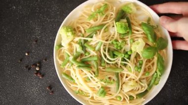 Spagetti sebzesi, bezelye, brokoli, çalı fasulyesi, kohlrabi vejetaryen makarna lezzetli makarna masanın üzerinde taze lezzetli gurme yemek.