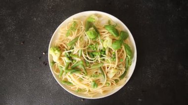 Spagetti sebzesi, bezelye, brokoli, çalı fasulyesi, kohlrabi vejetaryen makarna lezzetli makarna masanın üzerinde taze lezzetli gurme yemek.