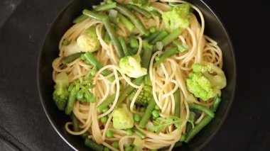 Spagetti sebzesi, bezelye, brokoli, çalı fasulyesi, kohlrabi vejetaryen makarna lezzetli makarna masanın üzerinde taze lezzetli gurme yemek.