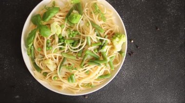Spagetti sebzesi, bezelye, brokoli, çalı fasulyesi, kohlrabi vejetaryen makarna lezzetli makarna masanın üzerinde taze lezzetli gurme yemek.