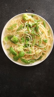 Spagetti sebzesi, bezelye, brokoli, çalı fasulyesi, kohlrabi vejetaryen makarna lezzetli makarna masanın üzerinde taze lezzetli gurme yemek.