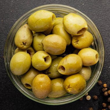 Yeşil zeytinler, çekirdeksiz doğal ürün turşusu. Lezzetli atıştırmalıklar. Lezzetli gurme yemek arkaplanı.