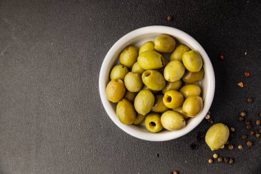 Yeşil zeytinler, çekirdeksiz doğal ürün turşusu. Lezzetli atıştırmalıklar. Lezzetli gurme yemek arkaplanı.