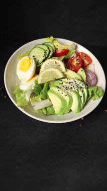 Avokado salata yumurtası, domates, soğan, yeşil yaprak salatası sebze, doğal çerez, lezzetli çerez, lezzetli gurme yemek arka planı, masa rustik üst görünüm fotokopi alanı keto ve paleo diyet vegan ve vejetaryen yemekleri.