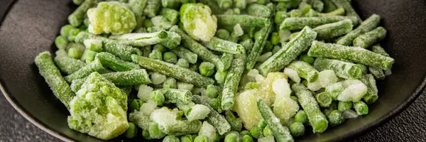 Donmuş yeşil sebzeler bezelye, brokoli, çalı fasulyesi, kohlrabi lahanası lezzetli çerez masadaki lezzetli gurme yemek arka planı rustik yemekler fotokopi alanı keto ve paleo diyeti vejetaryen ve vejetaryen yemekleri.