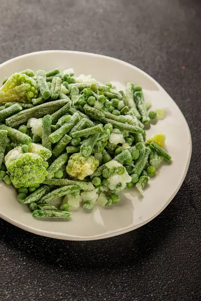 Donmuş yeşil sebzeler bezelye, brokoli, çalı fasulyesi, kohlrabi lahanası lezzetli çerez masadaki lezzetli gurme yemek arka planı rustik yemekler fotokopi alanı keto ve paleo diyeti vejetaryen ve vejetaryen yemekleri.