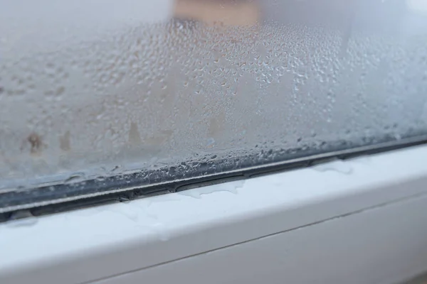 Water condensation on a window inside of a room during cold winter and warm room air, danger of mold growth