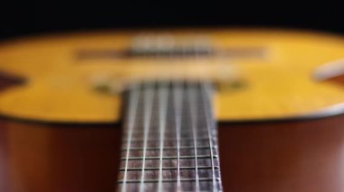 The Macro shot of classical guitar strings captures every detail of the strings and pickups, with a focus on the strings highlighting their tonal qualities and unique characteristics