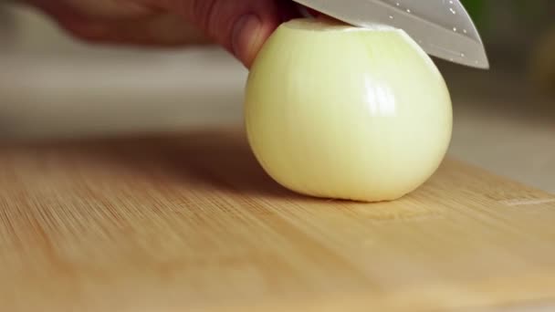 一个家庭厨师用木板上的刀把一个白色的洋葱切成两半 健康饮食 有机食品的概念 — 图库视频影像