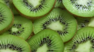 Canlı yeşil kivi dilimleri güzel bir şekilde sulu iç kısımlarını ve eşsiz, enfes dokularını gözler önüne seriyor.