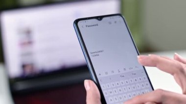 Aktif olarak akıllı bir telefonla yazmakla meşgul olan bir kişi, yakınlardaki bir dizüstü bilgisayarla kusursuz bağlantıyı vurguluyor.