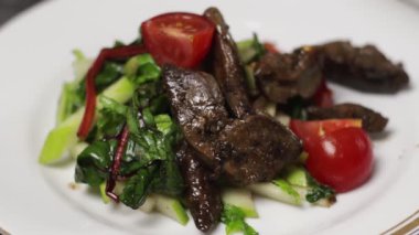 Taze yeşillik ve kiraz domatesli lezzetli bir sığır salatası. Sağlıklı beslenenler için mükemmel..