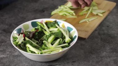 Canlı bir kase taze sebze ve gevrek kereviz. Mutfakta salata yapmanın heyecan verici sürecini gözler önüne seriyor.