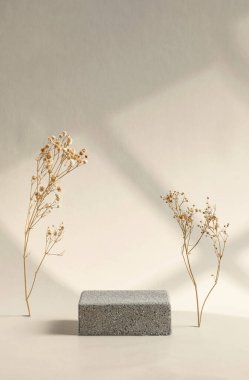 Pencereden gelen güneş ışığı ve krem rengi arka planda kuru çiçek ile en az taş aşamasında ürün gösterimi