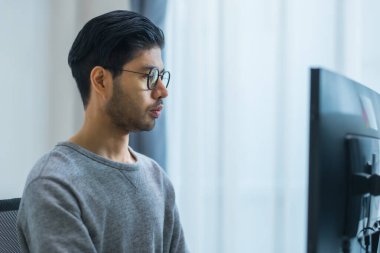 Ofiste bilgisayar monitörünün önünde duran yazılım verisi ile Asyalı komut mühendisi kodlama uygulaması