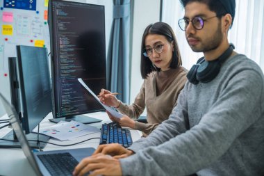 Asyalı ve Hintli Geliştirici ekibi ofisteki yazılım bilgisayarı ile geri bildirim analizi kodlama verilerini tartıştı