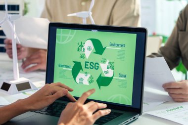 ESG ( environment, social,governance) recycle sign on laptop screen with carbon free chart board in office clipart