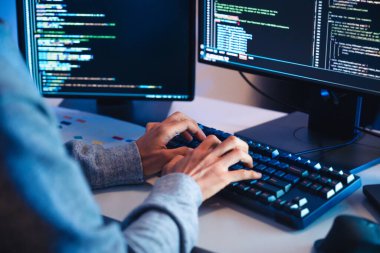 Asyalı mühendisin elini kapat. Yazılım verileri ile kodlama uygulaması geliştir. Ofiste bilgisayar monitörü önünde oturuyor.