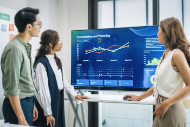 Finansal tartışma iş planlama ekibi, modern bir ofiste dijital finansal verileri ve stratejiyi analiz ediyor