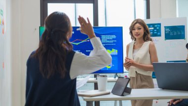 Lider bir gece toplantısında verileri incelerken finansal projeksiyonlar ve dijital raporlar ekranda gösterildiğinde