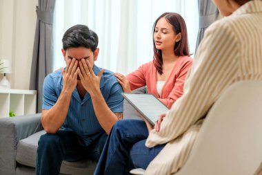 Bir çiftin terapi seansı sırasında sıkıntılı adam elleriyle yüzünü kapatıyor.