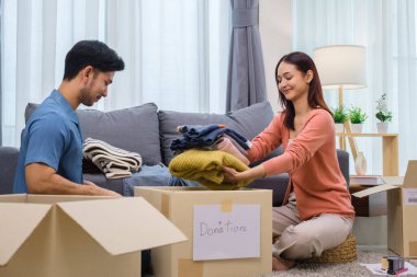 Bir grup arkadaş, kıyafetlerini bir bağış kutusuna yerleştiriyor ve paketliyor. Toplum desteği ve hayır kurumlarına bağış yapıyor.