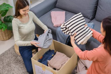 Bir grup arkadaş, kıyafetlerini bir bağış kutusuna yerleştiriyor ve paketliyor. Toplum desteği ve hayır kurumlarına bağış yapıyor.