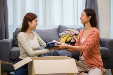 Bir grup arkadaş, kıyafetlerini bir bağış kutusuna yerleştiriyor ve paketliyor. Toplum desteği ve hayır kurumlarına bağış yapıyor.