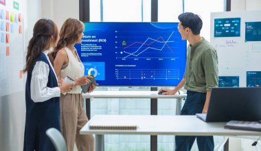 Finansal tartışma iş planlama ekibi, modern bir ofiste dijital finansal verileri ve stratejiyi analiz ediyor