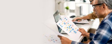 Bir acemi birliği kampı eğitimi sırasında akış çizelgelerini analiz eden bir grup Asyalı kıdemli yazılım geliştirici.