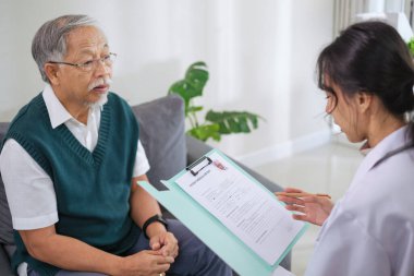 Klinikteki ya da hastanedeki yaşlı hastayla görüşürken Doktor Tıbbi Dosyayı İnceleme