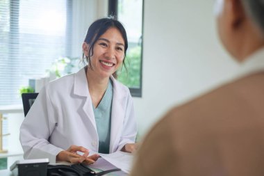 Klinikteki ya da hastanedeki yaşlı hastayla görüşürken Doktor Tıbbi Dosyayı İnceleme