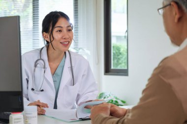 Klinikteki ya da hastanedeki yaşlı hastayla görüşürken Doktor Tıbbi Dosyayı İnceleme