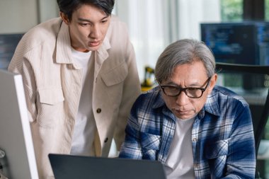 Bir acemi birliği kampı eğitimi sırasında akış çizelgelerini analiz eden bir grup Asyalı kıdemli yazılım geliştirici.