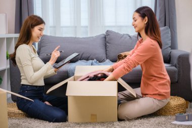 Bir grup arkadaş, kıyafetlerini bir bağış kutusuna yerleştiriyor ve paketliyor. Toplum desteği ve hayır kurumlarına bağış yapıyor.