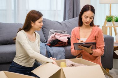 Bir grup arkadaş, kıyafetlerini bir bağış kutusuna yerleştiriyor ve paketliyor. Toplum desteği ve hayır kurumlarına bağış yapıyor.