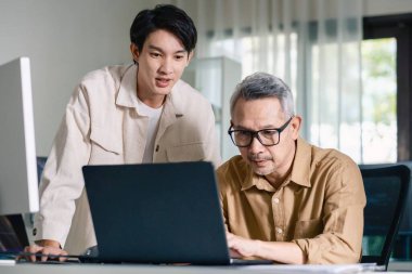 Bir acemi birliği kampı eğitimi sırasında akış çizelgelerini analiz eden bir grup Asyalı kıdemli yazılım geliştirici.