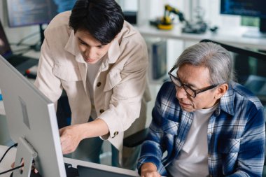 Bir acemi birliği kampı eğitimi sırasında akış çizelgelerini analiz eden bir grup Asyalı kıdemli yazılım geliştirici.