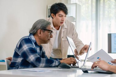 Bir acemi birliği kampı eğitimi sırasında akış çizelgelerini analiz eden bir grup Asyalı kıdemli yazılım geliştirici.