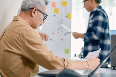 Kıdemli programcı bot kampı, Asyalı genç eğitmen kıdemli öğrencilere beyaz tahtadaki bir programlama, algoritma düşünme ve basit kod alıştırmaları yoluyla rehberlik ediyor.