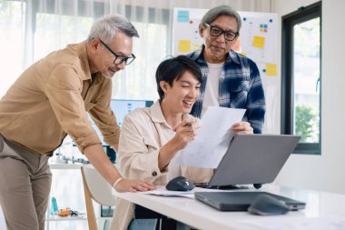 Bir acemi birliği kampı eğitimi sırasında akış çizelgelerini analiz eden bir grup Asyalı kıdemli yazılım geliştirici.